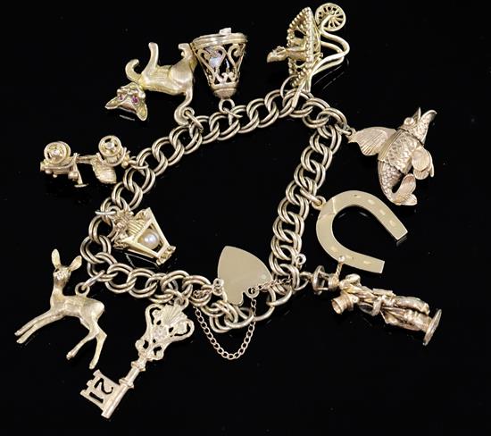 A 1960s 9ct gold charm bracelet, hung with ten assorted charms, gross 57 grams.